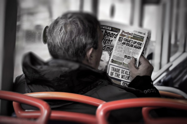 Man Reading Paper On Bus
