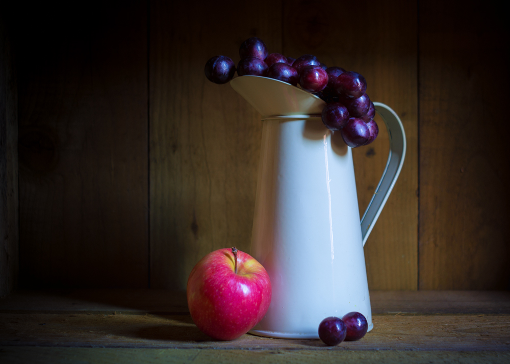 Ivory cream jug, with grapes and red apple.